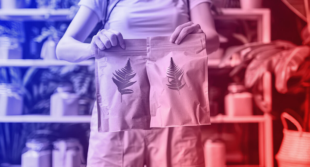 Green marketing – using sustainability as a USP: a businessman sits at a laptop in the indoor garden of an office building.