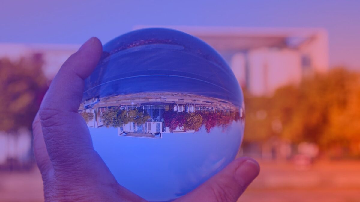 Glaskugel mit Kanzleramt-Spiegelung in Hand – Symbol für Zukunft der Digitalen Wirtschaft und Regierungspolitik