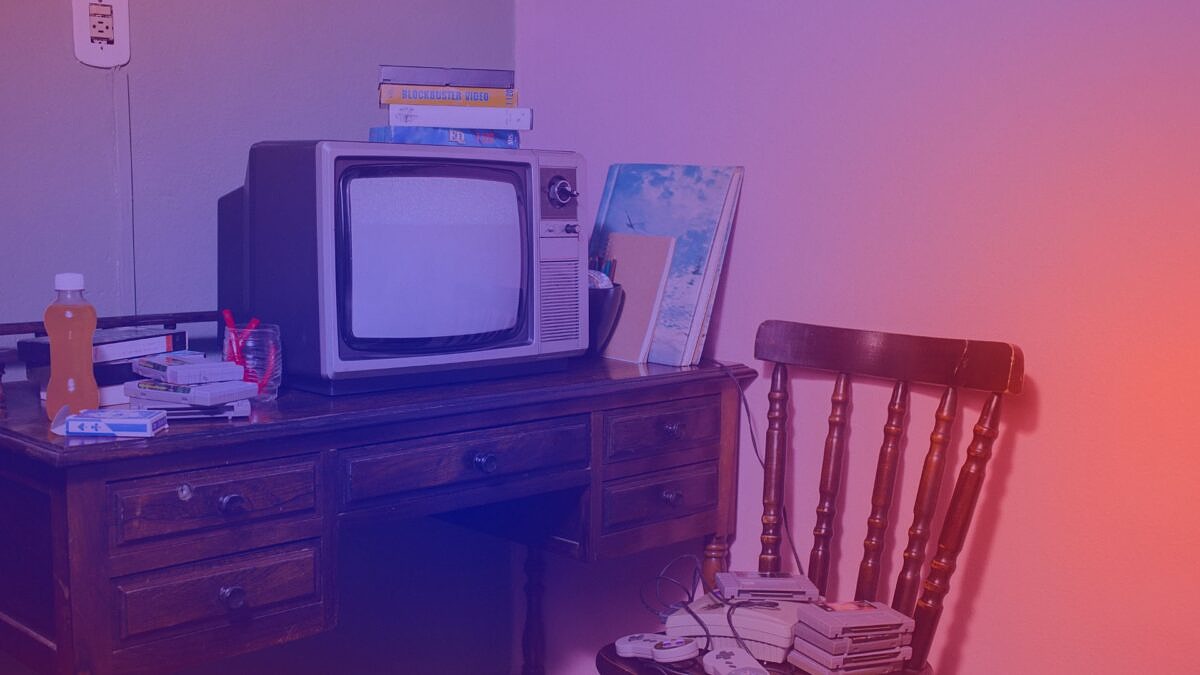 A desk with an old television set and VHS tapes