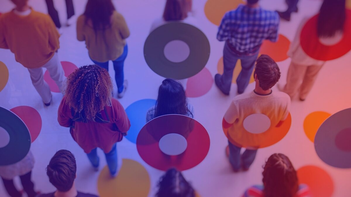 A diverse group of people with their backs to the viewer. Around them and on the floor are colorful circles